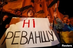 Участники митинга в Киеве держат плакат с надписью "Нет реваншу"