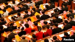Delegates fill in their ballots during an election at the plenary session of China's parliament, National People's Congress, at the Great Hall of the People in Beijing on March 15, 2008. 