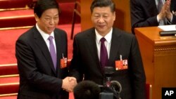 FILE - Chinese President Xi Jinping, right, poses with Li Zhanshu after Li was elected the new chairman of China's National People's Congress in Beijing, March 17, 2018. Xi will not attend celebrations of the 70th anniversary of North Korea's founding this weekend but will send Li, a top ally to represent him instead.