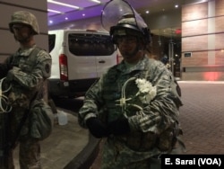 A National Guard officer smiles as he holds flowers given to him by a protester in Charlotte, North Carolina, Sept. 24, 2016.