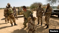 FILE - A U.S. special forces soldier demonstrates how to detain a suspect during Flintlock 2014, a U.S.-led international training mission for African militaries, in Diffa, Niger, March 4, 2014.