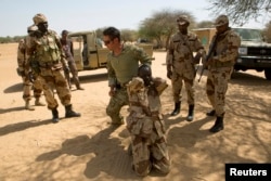 FILE - A U.S. special forces soldier demonstrates how to detain a suspect during Flintlock 2014, a U.S.-led international training mission for African militaries, in Diffa, Niger, March 4, 2014.