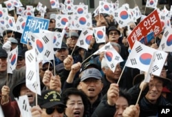 FILE - Protesters supporting South Korean President Park Geun-hye wave national flags during a rally opposing her resignation in Seoul, South Korea, Nov. 17, 2016.