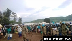 Les réfugiés en train de quitter le camp de Kamanyola encadrés par les éléments de la Mission de l’ONU, en direction du Rwanda, Kamanyola, Sud-Kivu, RDC, 7 mars 2018. (VOA/Ernest Muhero) 