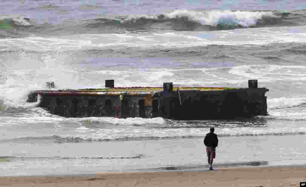 A man looks at the massive dock that washed ashore on Agate Beach on June 5, 2012, in Newport, Oregon. 