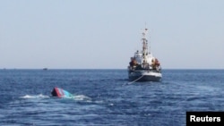 FILE - A Vietnamese boat (L) which was rammed and then sunk by Chinese vessels near disputed Paracels Islands in 2014.