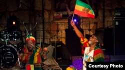 Vivien Jones stands behind the drummers waving the Jamaican flag at the Jerusalem Sacred Music Festival. (Courtesy Hanan Bar Assulin/Jerusalem Season of Culture)