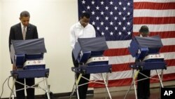 President Barack Obama (L) casts his vote during early voting in the 2012 election, at the Martin Luther King Community Center in Chicago, Illinois, October 25, 2012.