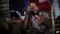 In this Nov. 24, 2017, photo, Li Juhar, who fled to Bangladesh from Myanmar's Rakhine State, becomes animated, forming both his hands into the shape of guns, when he speaks of soldiers flooding into his village.