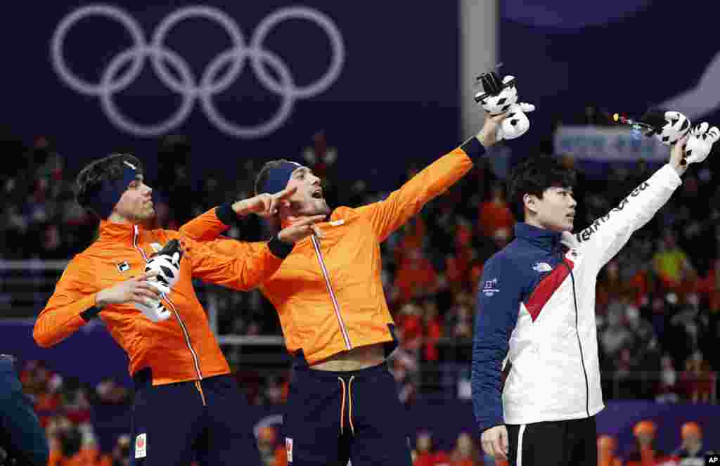 Gold medalist Kjeld Nuis of The Netherlands, center, and silver medalist Patrick Roest of The Netherlands, left, imitate Jamaican sprinter Usain Bolt, on the podium with bronze medalist Kim Min-seok of South Korea, right, after the men&#39;s 1,500 meters speedskating race at the Gangneung Oval at the 2018 Winter Olympics in Gangneung, Feb. 13, 2018.