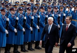 FILE - Montenegro's Prime Minister Dusko Markovic, left, escorted by his Serbian counterpart Aleksandar Vucic, reviews the honor guard during a welcoming ceremony at the Serbia Palace in Belgrade, Serbia, Feb. 3, 2017.