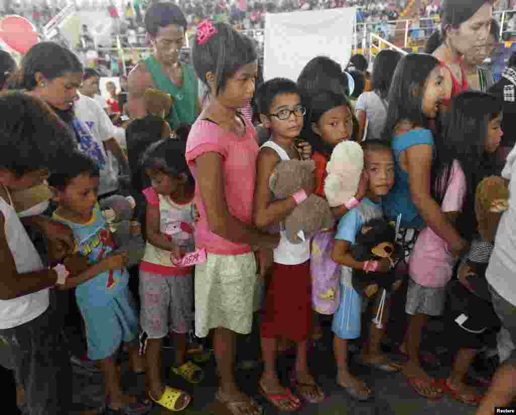 Survivors of Typhoon Haiyan line up during a gift-giving program inside an astrodome at Tacloban city, central Philippines. 