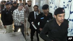 A US consulate employee identified by Pakistani authorities as Raymond Davis is escorted by police and officials in Lahore, Pakistan