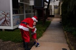 Pastor David Shrimpton, 57, yang dikenal sebagai "pastor terbang" menyapa siswa TK Tate Parlato, 6, saat menyampaikan pesan Natal di School of the Air di Broken Hill, Australia, 8 Desember 2021. (Foto: Reuters/Loren Elliott)