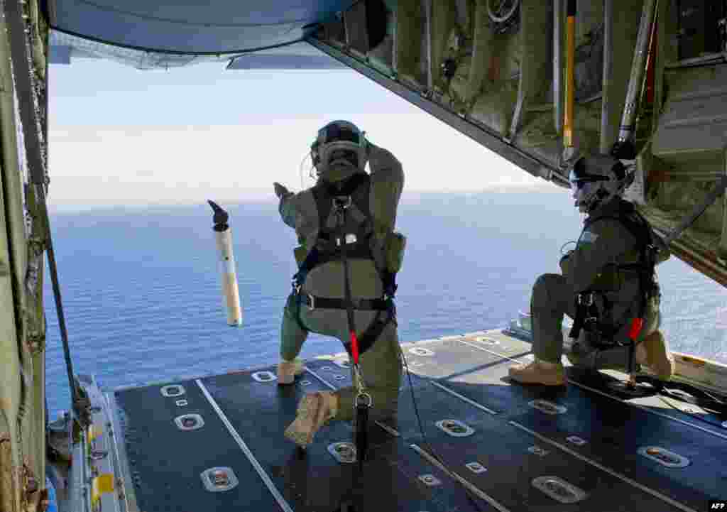 Royal Australian Air Force Loadmasters prepare to launch a Self Locating Data Marker Buoy from a C-130J Hercules aircraft over the southern Indian Ocean, March 20, 2014. (AFP PHOTO / AUSTRALIAN DEFENSE/LEADING SEAMAN JUSTIN BROWN)