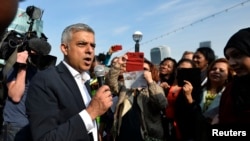 FILE - London Mayor Sadiq Khan speaks to supporters as he arrives for his first day at work at City Hall in London, May 9, 2016.