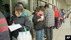 FILE - A line forms outside the Immigration and Naturalization Service office in Los Angeles, March 20, 1996.