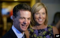 FILE - Republican David Trott, candidate for Michigan's 11th congressional district at the time, stands next to his wife, Kappy, during an interview at his election night party in Troy, Michigan, Aug. 5, 2014. In a statement Monday, Trott said he will not run for reelection.
