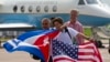 在古巴乘客展示美国和古巴国旗