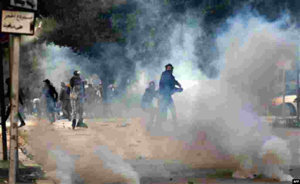 January 14: Demonstrators throws a stone at police during clashes in Tunis. Tunisia's president declared a state of emergency and announced that he would fire his government as violent protests escalated Friday, with gunfire echoing in the North African c