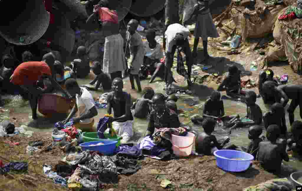 Des personnes déplacées se baignent et nettoient leurs habits dans une rivière dans l&rsquo;enceinte d&rsquo;une base de l&rsquo;ONU, après de récents affrontements à Juba, 27 décembre 2013. (AP Photo/Ben Curtis, Archives).