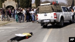 An effigy of the killer of right wing leader Eugene TerreBlanche is dragged behind a vehicle past protesters outside the court in Ventersdorp, South Africa, August 22, 2012. 
