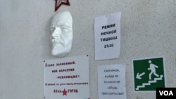 A face mask of Russian communist revolutionary Vladimir Lenin is seen mounted on a wall at the Vershina-Navigator Foundation's rehabilitation center. The sign beneath reads “I’m also addicted. Revolution is my narcotic!”