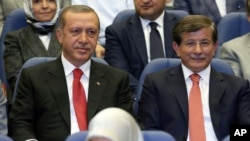 Turkey's president-elect Recep Tayyip Erdogan (L) and Foreign Minister Ahmet Davutoglu sit together during a party meeting in Ankara, Turkey, Aug. 21, 2014.