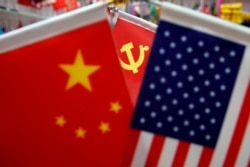 China, FILE PHOTO: The flags of China, U.S. and the Chinese Communist Party are displayed in a flag stall at the Yiwu Wholesale Market in Yiwu, Zhejiang province