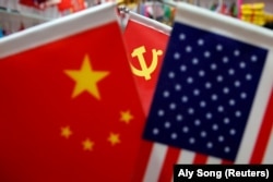 China, FILE PHOTO: The flags of China, U.S. and the Chinese Communist Party are displayed in a flag stall at the Yiwu Wholesale Market in Yiwu, Zhejiang province