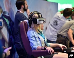 A woman wears a virtual reality display at a computer and video game event in Cologne, Germany, Aug. 5, 2015.