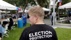 Lisa Hubbard, a volunteer with the non-partisan Election Protection Coalition, attends an early voting celebration outside of Jackson Memorial Hospital, on the first day of early voting in Miami-Dade County for the general election, Oct. 24, 2016, in Miam