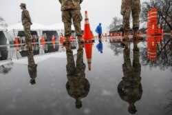 National Guard personnel stand at attention as they wait for patients to arrive for COVID-19 coronavirus testing facility at Glen Island Park, in New Rochelle, N.Y.