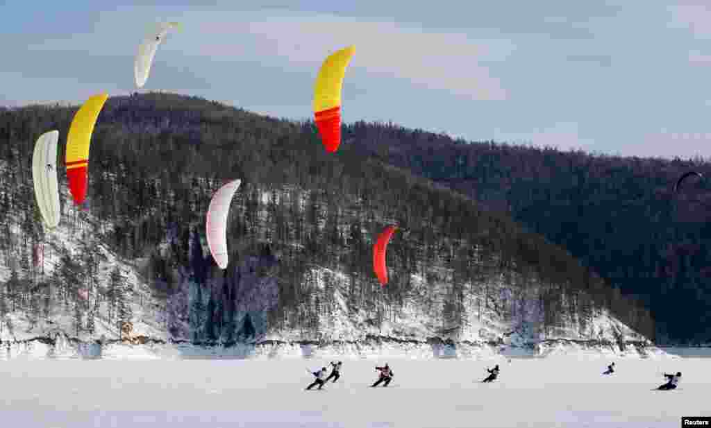 Kite skiers compete during the first snowkiting championship of the Siberian and Far Eastern Federal Districts on the ice-covered Yenisei River outside Krasnoyarsk, Russia, Feb. 23, 2019.