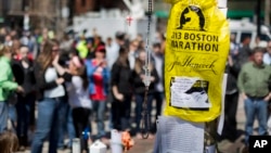 Visitors pause at a makeshift memorial in Copley Square for victims of the Boston Marathon bombings, Apr. 27, 2013, in Boston, Mass.