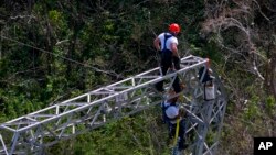 FILE - Whitefish Energy Holdings workers restore power lines damaged by Hurricane Maria in Barceloneta, Puerto Rico, Oct. 15, 2017.