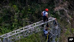 ARCHIVO - Los trabajadores de Whitefish Energy Holdings, restauran las líneas eléctricas dañadas por el huracán María en Barceloneta, Puerto Rico, el 15 de octubre de 2017.