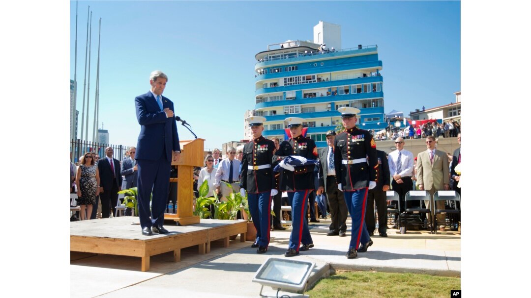 Menteri Luar Negeri AS John Kerry menyaksikan Marinir AS yang ditempatkan di Kuba membawa bendera Amerika dalam upacara penaikan bendera di Kedutaan Besar AS di Havana, Kuba (14/8).