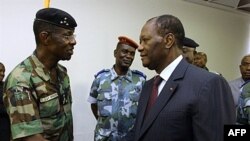 Tổng thống Côte d'Ivoire Alassane Ouattara, phải, bắt tay tướng Philippe Mangou, cựu Tổng tham mưu trưởng quân đội của ông Gbagbo, 12/4/2011