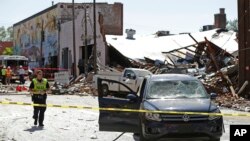 Bomberos y personal de emergencia trabajan en el lugar donde un edificio se incendió luego de una explosión en el centro de Durham, Carolina del Norte. Abril 10 de 2019.