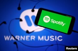 Layanan streaming musik "Spotify" dan logo label "Warner Music". (Foto: ilustrasi).