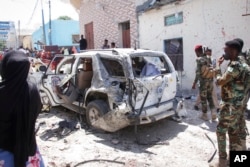 FILE - Security forces observe the scene of a suicide bombing in Mogadishu, Somalia, Jan. 16, 2022.