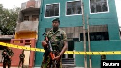 Special Task Force Commandos stand guard outside a vandalized mosque in Colombo, Sri Lanka, Aug. 11, 2013.
