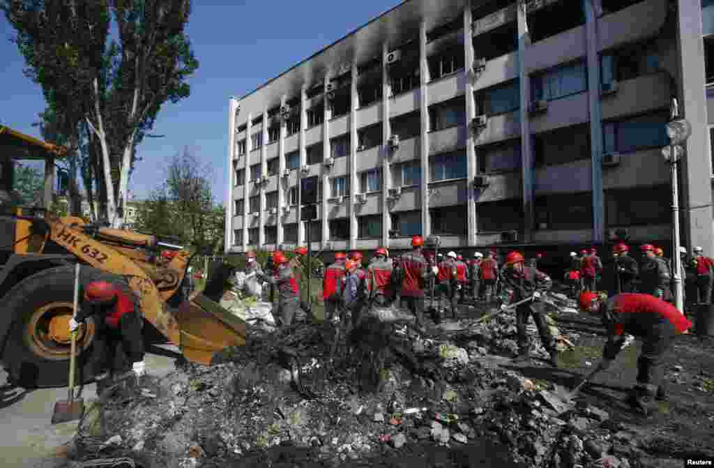 Workers of Metinvest, majority-owned by multi-billionaire Rinat Akhmetov's System Capital Management, remove barricades and debris in front of the City Hall, in Mariupol, May 14, 2014.