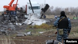 FILE - A pro-Russian armed man secures crash site wreckage of the Malaysia Airlines Flight MH17 at the site of the plane crash near the settlement of Grabovo in the Donetsk region, Nov. 16, 2014. 