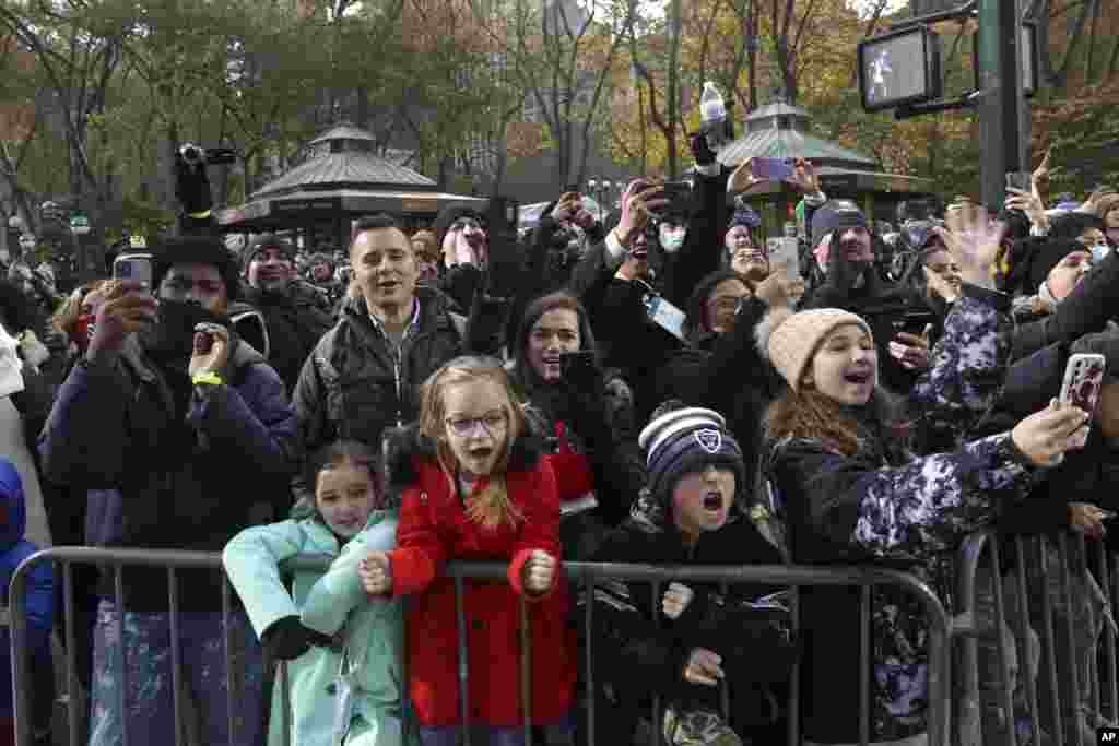 Spectators react to floats and balloons as they pass Bryant Park during the Macy&#39;s Thanksgiving Day Parade in New York.