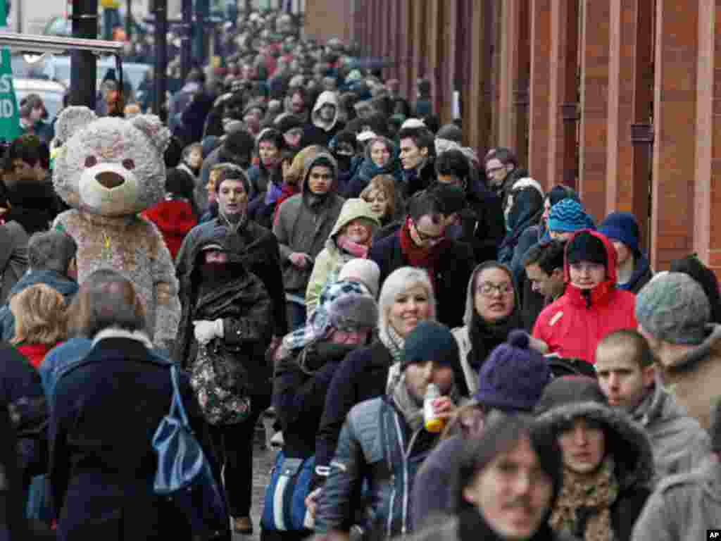 A performer dressed as a bear entertains Eurostar passengers queueing for trains at St Pancras station, in London December 21, 2010. Snow and freezing temperatures grounded flights and disrupted road and rail links across northern Europe on Monday, strand