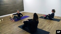 In this January 16, 2019 photo, writer and editor Camille LeFevre, left, leads a pilates work at ModernWell in Minneapolis.