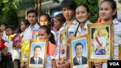 សិស្សានុសិស្ស​រាប់រយ​នាក់​​កាន់​រូបថត​ប្រធានា​ធិបតី​ចិន​ Xi Jinping​ និង​សម្ដេច​ព្រះ​​បរមនាថ​នរោត្តម​សីហមុនី ស្វាគមន៍​លោក​ក្នុង​​ទស្សន​កិច្ច​ផ្លូវ​រដ្ឋ​នៅ​កម្ពុជារបស់​លោក​ប្រធានាធិបតី​ចិន​​ នៅ​ថ្ងៃ​ព្រហស្បតិ៍ ទី១៣ ខែ​តុលា​ ឆ្នាំ​២០១៦ នា​រាជធានី​ភ្នំពេញ​។ ​( ឡេង ឡែន/VOA)