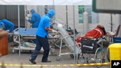 Seorang petugas medis memindahkan tangki oksigen yang akan digunakan untuk merawat pasien di tenda darurat yang didirikan untuk menampung lonjakan kasus COVID-19, di Rumah Sakit Pusat Dr. Sardjito Yogyakarta, Minggu, 4 Juli 2021. (AP Photo/Kalandra)
